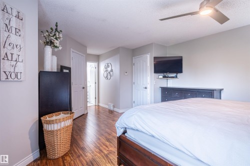 Wood-finish flooring throughout, ceiling fan with integrated lighting, and white trim work - 38 Dubonnet Way, St. Albert, AB 