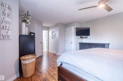 Wood-finish flooring throughout, ceiling fan with integrated lighting, and white trim work - 