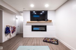 Shiplap accent wall with built-in electric fireplace and wood mantel - 