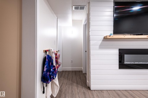 Shiplap accent wall with an integrated electric fireplace and a wood mantel - 38 Dubonnet Way, St. Albert, AB 