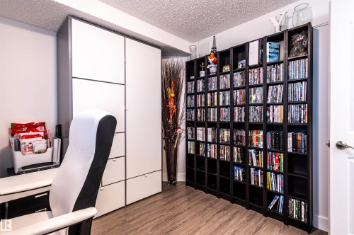 Recessed white built-in cabinetry, wood-finish flooring, and black shelving units - 38 Dubonnet Way, St. Albert, AB 