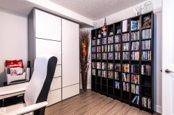 Recessed white built-in cabinetry, wood-finish flooring, and black shelving units - 