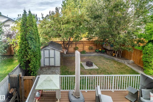 Spacious backyard featuring a wood deck, white railing, and a storage shed - 38 Dubonnet Way, St. Albert, AB 