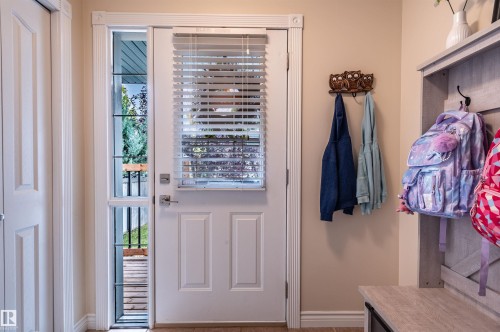 White paneled door with integrated blinds and full-length sidelight, featuring wood-finish flooring - 38 Dubonnet Way, St. Albert, AB 