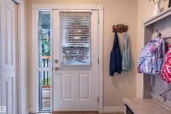 White paneled door with integrated blinds and full-length sidelight, featuring wood-finish flooring - 