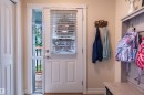 White paneled door with integrated blinds and full-length sidelight, featuring wood-finish flooring - 38 Dubonnet Way, St. Albert, AB 