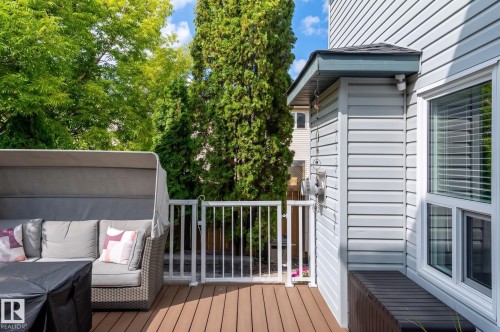 Wood-finish deck with white railings and vinyl siding - 38 Dubonnet Way, St. Albert, AB 