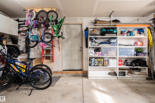 Concrete flooring with built-in shelving, overhead storage, and a service door - 38 Dubonnet Way, St. Albert, AB 