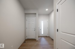 Entryway featuring light wood-finish flooring, recessed ceiling lighting, and a front door with an integrated vertical window - 