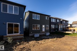 Two-story exterior with dark horizontal siding, white-framed windows, and a sliding glass door - 