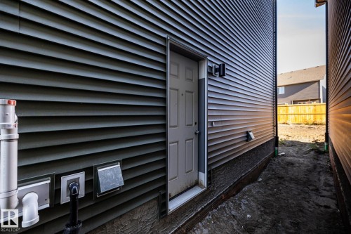 Dark gray horizontal siding with a side entry door - 2358 Muckleplum Way Sw, Edmonton, AB 