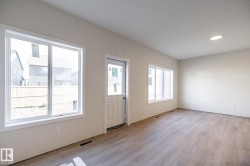 Recessed lighting, wood-finish flooring, multiple windows, and a rear exterior door - 