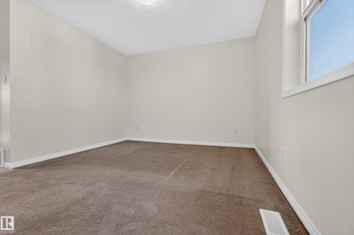 Neutral-toned walls, brown carpeting, and a white-framed window - 6933 21A Avenue Sw, Edmonton, AB 