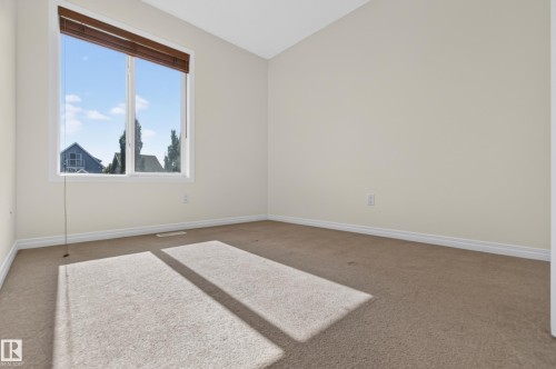 Bright room featuring a large window with brown wood blinds and neutral carpeting - 6933 21A Avenue Sw, Edmonton, AB 