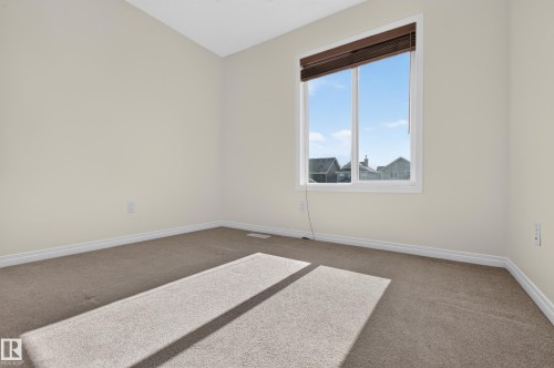 Neutral wall paint, carpeted flooring, and a large window with blinds - 6933 21A Avenue Sw, Edmonton, AB 