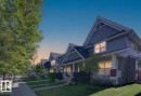 Siding exterior with dormer windows, covered front porch, and manicured lawn - 6933 21A Avenue Sw, Edmonton, AB 