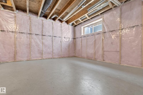 Unfinished space featuring exposed ceiling joists, insulation with vapor barrier, and a concrete floor - 6933 21A Avenue Sw, Edmonton, AB 