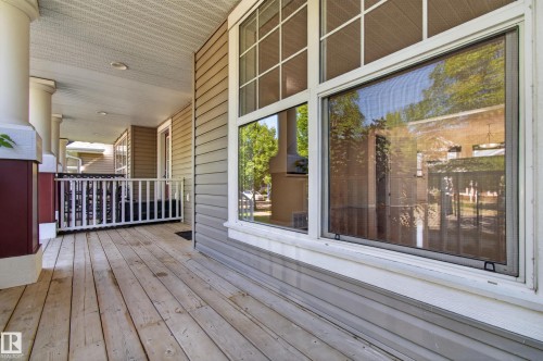 Expansive wood deck with decorative railings, supported by substantial columns - 6933 21A Avenue Sw, Edmonton, AB 