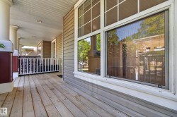 Expansive wood deck with decorative railings, supported by substantial columns - 