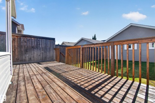 Wood-plank deck with a wood railing and privacy fencing - 6933 21A Avenue Sw, Edmonton, AB 