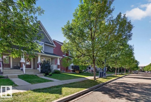 Gabled roofline, front porch with columns, front entry door, sidewalk, and street - 6933 21A Avenue Sw, Edmonton, AB 