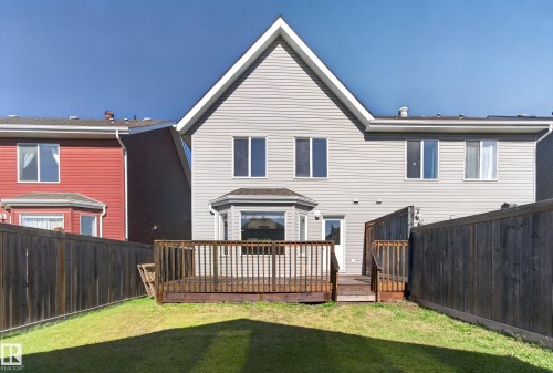 Private fenced backyard featuring a wooden deck and a bay window - 6933 21A Avenue Sw, Edmonton, AB 