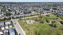 Expansive neighborhood featuring residential properties, a dedicated park area with playground equipment, walking paths, and mature trees - 