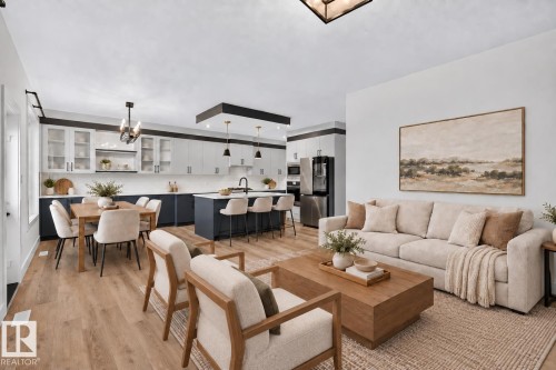 Open-concept living space featuring wood-finish flooring, a kitchen with two-tone cabinetry and stainless-steel appliances, a kitchen island with seating, and recessed lighting - 22 Sydwyck Circle, Spruce Grove, AB 