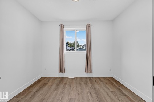 Wood-finish flooring with white baseboards and neutral wall paint - 22 Sydwyck Circle, Spruce Grove, AB 
