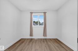 Wood-finish flooring with white baseboards and neutral wall paint - 