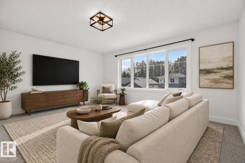 Spacious room with large windows, white walls, and a modern flush mount light fixture - 22 Sydwyck Circle, Spruce Grove, AB 