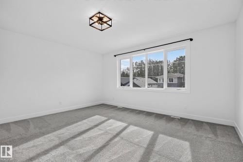 White walls, gray carpeting, and a large window with white trim - 22 Sydwyck Circle, Spruce Grove, AB 