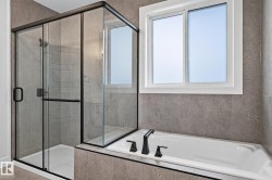 Glass-enclosed shower with matte black hardware, integrated bathtub, and tiled surround - 