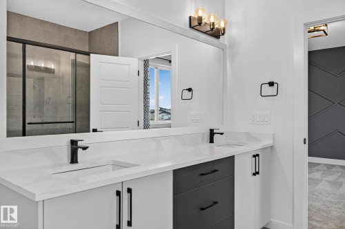 Dual vanity with integrated sinks, white countertops, and matte black fixtures - 22 Sydwyck Circle, Spruce Grove, AB 