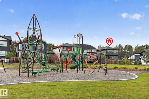 Community playground featuring varied climbing structures, slides, and wood chip surfacing - 22 Sydwyck Circle, Spruce Grove, AB 