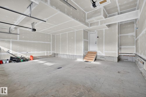 Concrete flooring with a finished entry door and wood stairs - 22 Sydwyck Circle, Spruce Grove, AB 