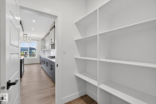 Spacious built-in pantry shelving with wood-finish flooring - 22 Sydwyck Circle, Spruce Grove, AB 