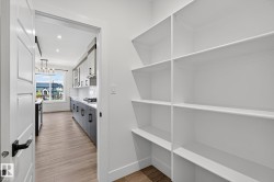Spacious built-in pantry shelving with wood-finish flooring - 