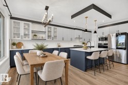 Open-concept kitchen and dining area featuring wood-finish flooring, two-tone cabinetry with glass-front upper cabinets, a kitchen island with seating, and stainless steel appliances - 
