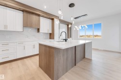 Contemporary kitchen featuring white cabinetry, wood-finish accents, and light wood-finish flooring - 