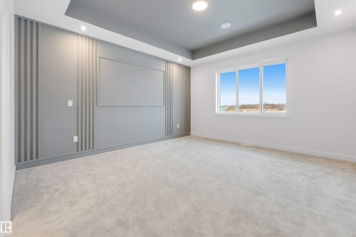 Recessed lighting, tray ceiling, custom accent wall paneling, light-toned carpeting, and a large multi-pane window - 13 Trill Point(E), Spruce Grove, AB 