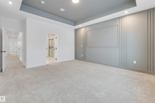 Recessed lighting, tray ceiling, textured accent wall, plush carpeting, and multiple doorways - 13 Trill Point(E), Spruce Grove, AB 