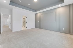 Recessed lighting, tray ceiling, textured accent wall, plush carpeting, and multiple doorways - 