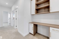 Built-in desk with wood-finish countertop, integrated cabinetry, open shelving, and recessed lighting - 