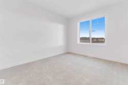 Bright room featuring light gray carpet flooring, white walls, and a large window with white trim - 