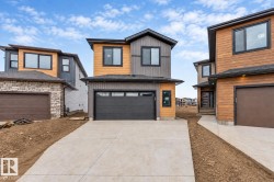 Contemporary exterior with horizontal wood-finish siding, dark trim, and a black garage door - 