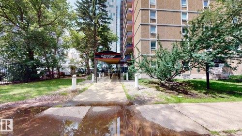 Building exterior featuring a covered walkway entrance with signage - #307 10140 120 Street Nw, Edmonton, AB - Outdoor