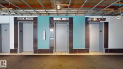 Three elevator entrances featuring stainless steel accents and a turquoise wall panel - 