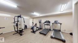 Amenity fitness center featuring wood-finish flooring and track lighting - 