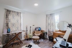 Wood-finish flooring with white walls and a ceiling-mounted light fixture - 